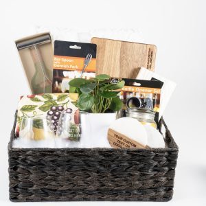 Personalized housewarming gift basket with custom engraved wood cutting board, two custom glasses, 2 engraved coasters, and premium throw blanket.