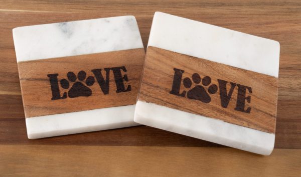 Set of two square white marble and wood pet coasters with laser engraved LOVE paw print design.