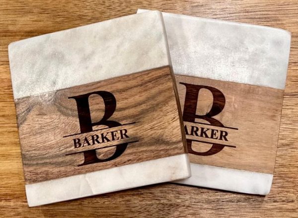 Personalized marble and wood square coasters with custom family name engraving.