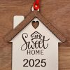 Personalized wood housewarming ornament with Home Sweet Home and current year engraving.