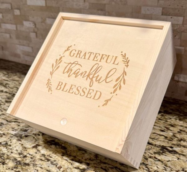 Custom corporate gift boxes made of wood with laser engraved company logo on the sliding lid.