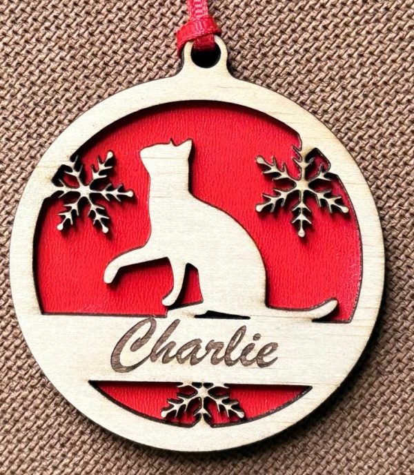 Personalized wood cat ornament with custom engraved name hanging on a Christmas tree