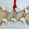 Personalized dog bone ornament laser engraved with multiple pet names and pawprints from Ohio Basket Chic
